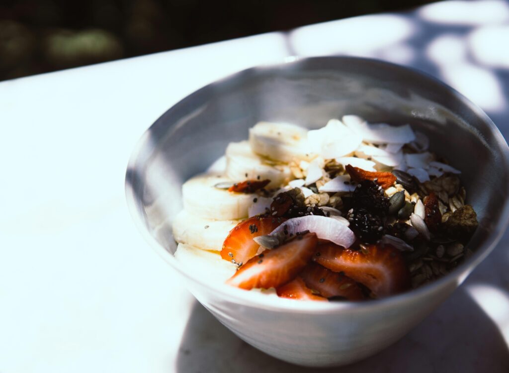 A refreshing bowl of sliced fruits, coconut flakes, and seeds for a nutritious start.